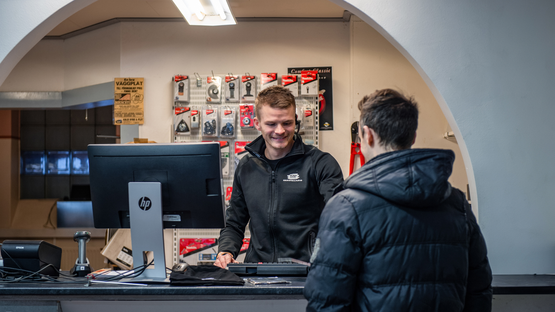 Person står i kassan och tar emot kund